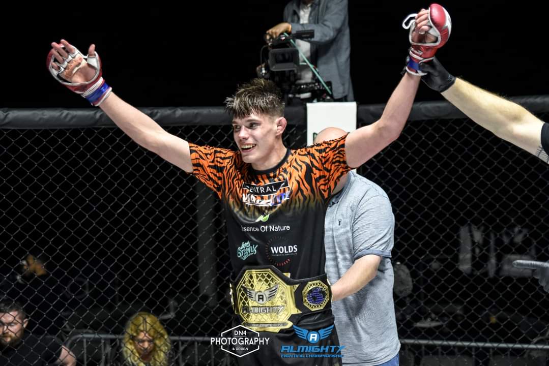 Fighter winning title in black and orange custom tee and shorts